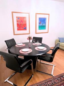 een eettafel met 4 stoelen en een zwarte tafel bij Good Old Times Apt II in Wenen