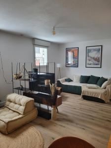 a living room with a bed and a couch at Cocon Gérardmer à 5min du Lac in Gérardmer