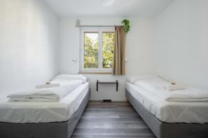 2 camas en una habitación con ventana en Moderne Wohnung mit Parkplatz en Ostermundigen