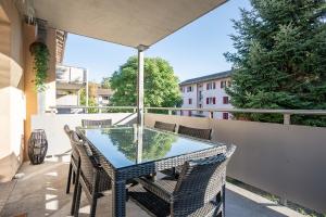 patio con mesa de cristal y sillas en el balcón en Moderne Wohnung mit Parkplatz en Ostermundigen