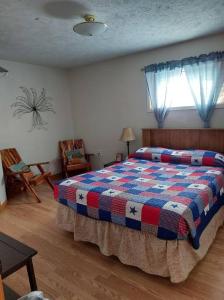 1 dormitorio con 1 cama con manta a cuadros en Barn house en Saint Joe