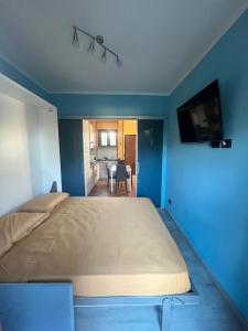蒂勒尼亞的住宿－Appartamento da Matteo 2，卧室内的一张大床,卧室内有蓝色的墙壁