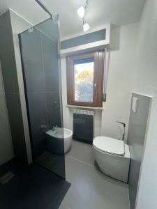 uma casa de banho com um WC, um lavatório e uma janela em Appartamento da Matteo 2 em Tirrenia