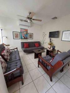 a living room with couches and a ceiling fan at Villa de Ali in Palma real in La Ceiba
