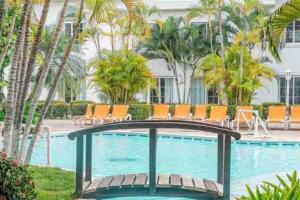 a swimming pool with orange chairs in a resort at Villa de Ali in Palma real in La Ceiba