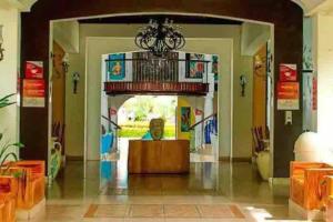 a man sitting at a table in a lobby at Villa de Ali in Palma real in La Ceiba