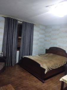 sypialnia z łóżkiem i oknem z zasłonami w obiekcie BBQ House w mieście Dilidżan