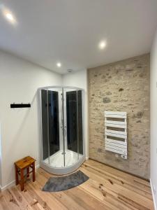 een grote glazen douche in een kamer met een houten vloer bij Cosy house in Casteljaloux