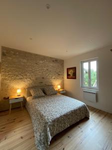 um quarto com uma cama e duas mesas e uma janela em Cosy house em Casteljaloux