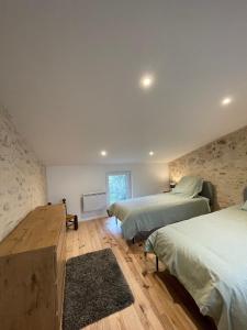 een slaapkamer met 2 bedden en een houten vloer bij Cosy house in Casteljaloux