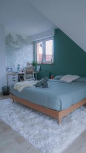 a bedroom with a large bed with a green wall at Cocoon Bed and Breakfast in Fegersheim