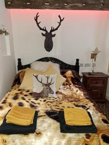 a bedroom with a bed with a deer head on it at Willow's Cottage in Edwinstowe