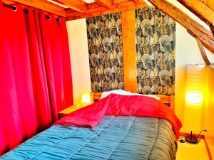 1 dormitorio con cortinas rojas y 1 cama azul en Gîte 3 étoiles - Spacieux et confortable ancienne grange rénovée - Cantal Emotions Valette - Auvergne, en Valette