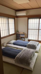 松島雅居 في طوكيو: سريرين يجلسون في غرفة مع نوافذ