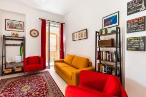 a living room with a yellow couch and red chairs at Casa Soliva in Palermo
