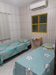 um quarto com duas camas e uma mesa e uma janela em Casa Eco Via Norte - MCZ em Maceió
