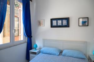 a bedroom with a bed and a window at Casa Soliva in Palermo