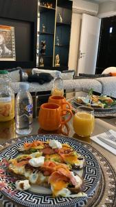 a table with two plates of food and orange juice at Luxury apartment by versace in Istanbul