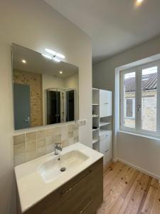 een badkamer met een wastafel en een spiegel bij Cosy house in Casteljaloux