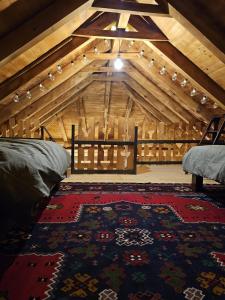 a attic room with two beds and a rug at Eko kuća Zlatiborsko srce in Zlatibor