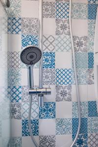 a shower with a stool in a bathroom with blue and white tiles at Casa Soliva in Palermo