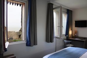 a hotel room with a bed and a window at La Confiance in Le Mont Saint Michel