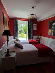 Schlafzimmer mit einem Bett mit roten Wänden und einem Fenster in der Unterkunft Gîte Marguerite - Au coeur de la campagne in La Petite-Boissière