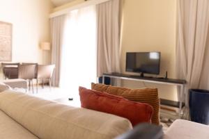 uma sala de estar com um sofá e uma televisão de ecrã plano em Loft em ótima localização em Salvador