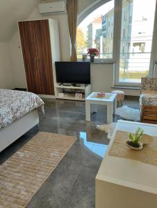 a living room with a bed and a tv at Apartma Azurre in Postojna