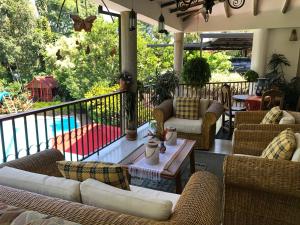 une terrasse couverte avec des canapés et une table sur un balcon dans l'établissement Finca El Remanso La Vega, à La Vega