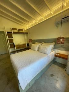 una camera con letto bianco e letti a castello di Casa5 a Arraial d'Ajuda