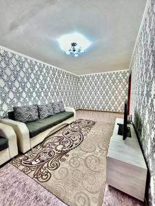a living room with a couch and a rug at Аренда с Самостоятельным Заездом in Pavlodar