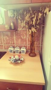 a table with a vase and three bowls on it at Apartman Centar in Kruševac