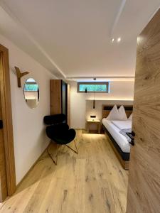 um quarto com uma cama e uma cadeira num quarto em DAS MANFRED em Sankt Michael im Lungau