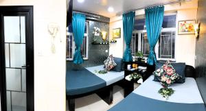 two beds in a room with blue curtains at Park Guesthouse in Hong Kong