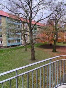 einen Zaun vor einem Gebäude mit Bäumen in der Unterkunft Möblierte Wohnung Hannover List in Hannover