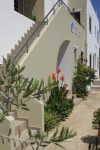 a building with stairs and flowers in front of it at Xenios Zeus Apartments in Kissamos