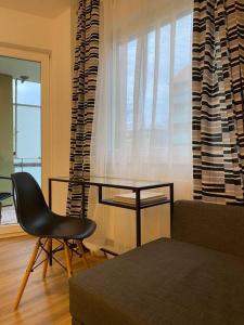 a living room with a chair and a table and a window at Möblierte Wohnung Hannover List in Hannover