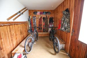 2 bicicletas están estacionadas en una habitación con paredes de madera en Horská chata Medika, en Horní Maršov
