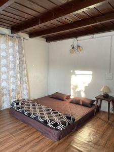 a large bed in a bedroom with a wooden floor at MANDAP COTTAGE & CAFE in Nagar