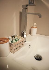 ein Waschbecken mit einem Seifenspender neben einem Wasserhahn in der Unterkunft Maison Chez Les Roset in Baulen