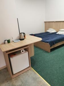a room with two beds and a table with a tv at Olimpijka Lidia Wrzesinska in Więcbork