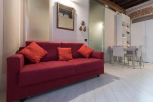 a red couch in a living room with a table at Perla al centro di Torino - next Mole in Turin +7 photos