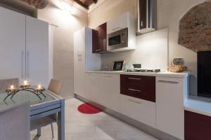uma cozinha com armários brancos, uma mesa e um balcão em Perla al centro di Torino - next Mole em Turim