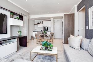 a living room with a couch and a table at Urban Oasis Apartments at Masingita Towers in Johannesburg