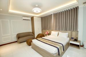 Habitación de hotel con cama y silla en Biển Sao 2 Hotel GV, en Ho Chi Minh