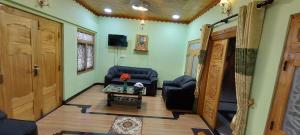 een woonkamer met 2 stoelen en een tafel bij Karainagar Holiday Home 