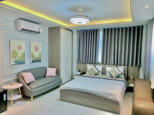 1 dormitorio con 1 cama y 1 sofá en Biển Sao 2 Hotel GV, en Ho Chi Minh