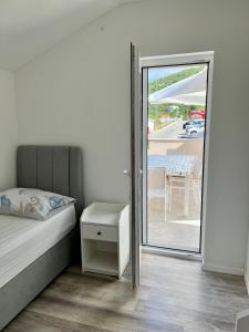 a bedroom with a bed and a mirror and a table at Novo uređeni apartman sa velikom terasom in Vis