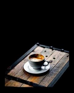 a cup of coffee sitting on a wooden table at Saint patrick guest house in Barletta